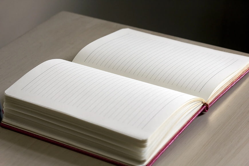 Open Lined Notebook on Wooden Desk Surface