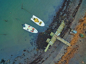 Aerial view of boats docked at a rustic wooden pier