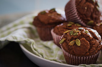 Close-up of homemade pumpkin muffins with seeds on a plate
