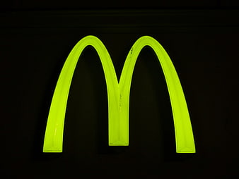 Illuminated Neon Green Letter M Sign On Black Background