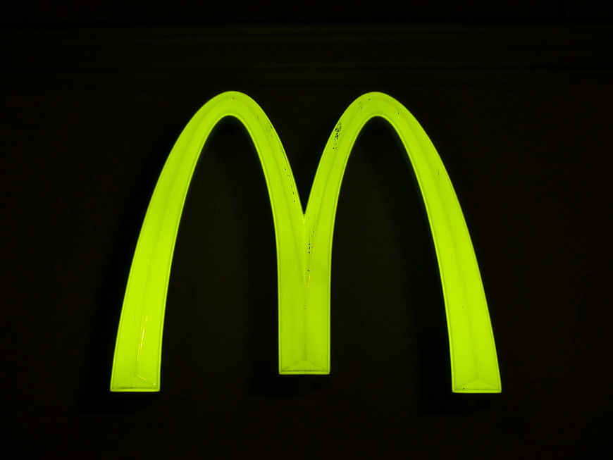 Illuminated Neon Green Letter M Sign On Black Background