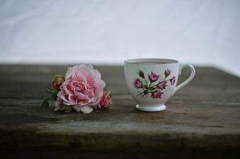 Vintage Tea Cup and Pink Rose on Wooden Table