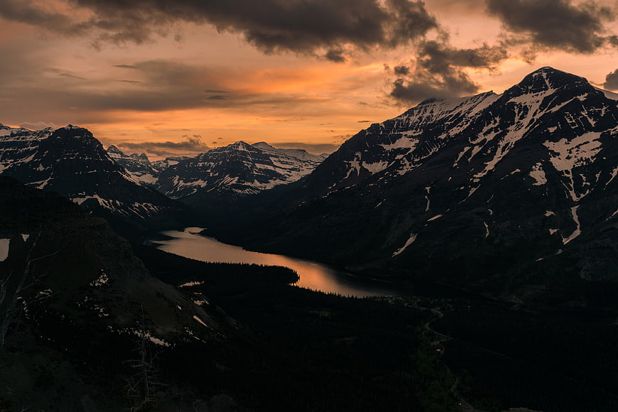 Dramatic Sunset Over Snowy Mountain Valley and Lake