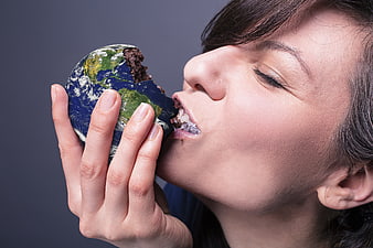 Woman eating a chocolate cake shaped like the Earth