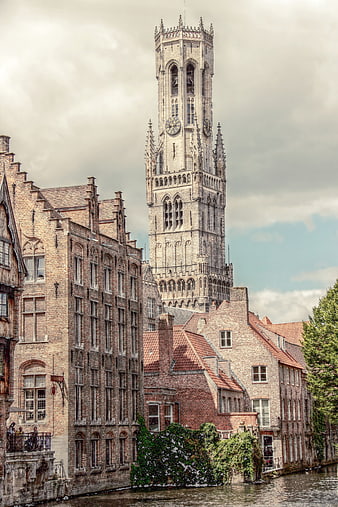 Historic Belfry Tower and Brick Buildings Along Canal in Bruges