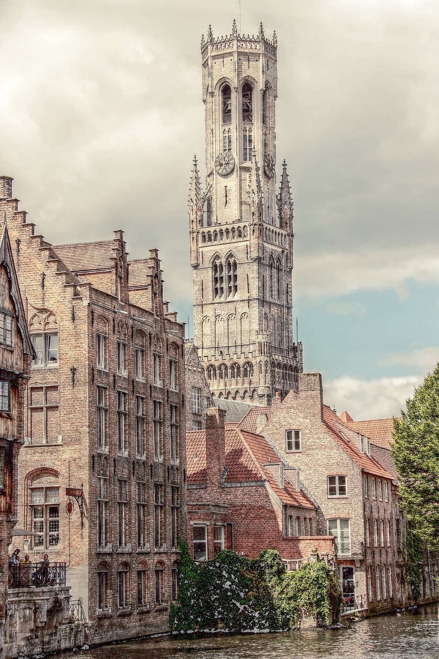 Historic Belfry Tower and Brick Buildings Along Canal in Bruges