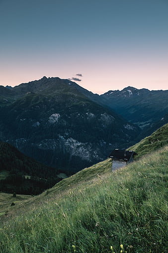 Solitary Mountain Hut in Alpine Meadow at Dusk