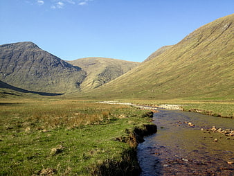 Scenic Mountain Valley with Flowing Stream and Green Hills