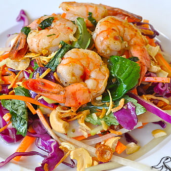Close-up of fresh shrimp salad with vegetables and herbs
