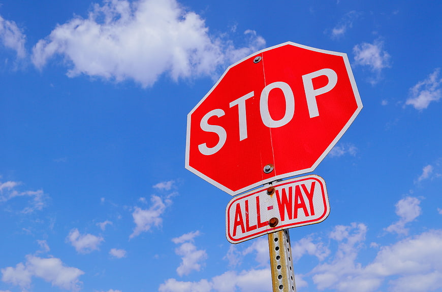 Red Stop Sign Against Blue Sky with Clouds