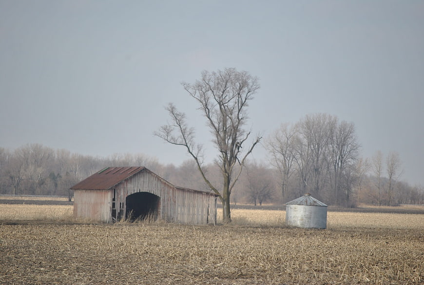 Rustic Covered Barn and Silo in Winter Field