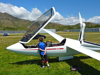 Young Boy Looking at White Ultralight Aircraft on Airfield