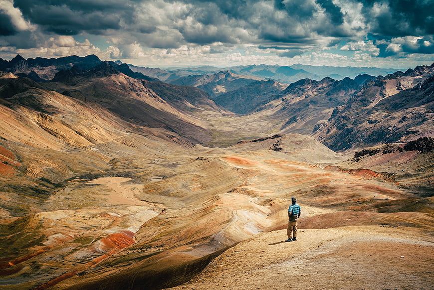 Lone Hiker Overlooking Vast Arid Mountain Valley Landscape