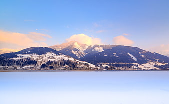 Serene Winter Landscape with Snow-Capped Mountains and Frozen Lake
