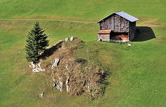 Aerial View Of Rustic Wooden Alpine Barn In Green Meadow
