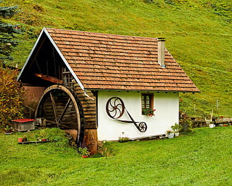 Traditional Water Mill with Wheel in Green Alpine Landscape