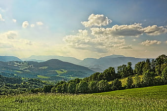 Scenic Mountain Landscape With Green Fields And Blue Sky