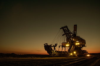 Silhouette of massive bucket wheel excavator at dusk