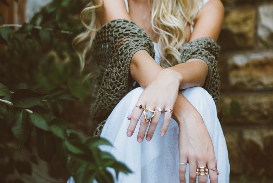 Woman wearing boho rings and crochet cardigan outdoors