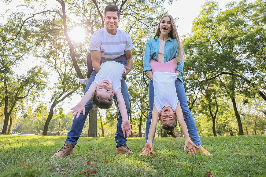 Happy family playing upside down in sunny park