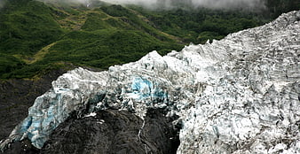 Majestic Glacier with Blue Ice and Green Mountain Background
