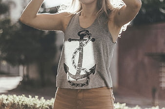 Woman wearing grey tank top with anchor graphic