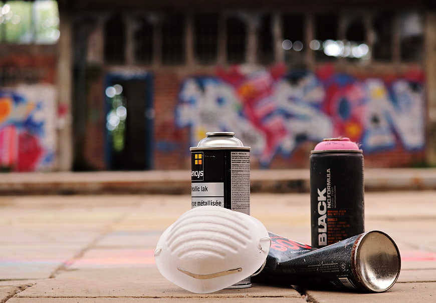 Spray paint cans and mask on abandoned station floor