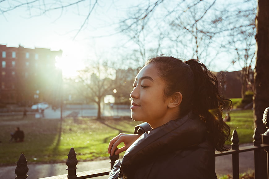Serene Asian Woman Portrait in Park with Golden Sunlight