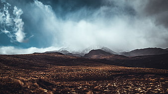 Dramatic Mountain Landscape with Stormy Clouds and Golden Grass
