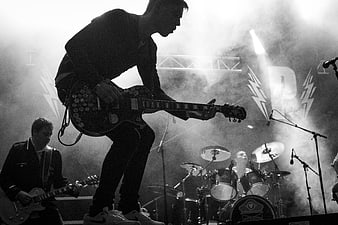 Rock band performing live on stage with smoke and lights