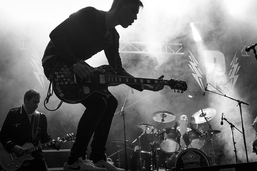 Rock band performing live on stage with smoke and lights