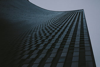 Low angle view of modern curved glass skyscraper facade