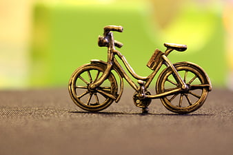 Vintage Bronze Bicycle Figurine on Textured Surface