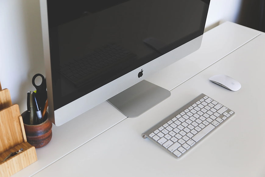 Minimalist white desk with iMac computer setup