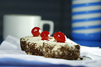 Chocolate cake slices with red cherries and coffee cup