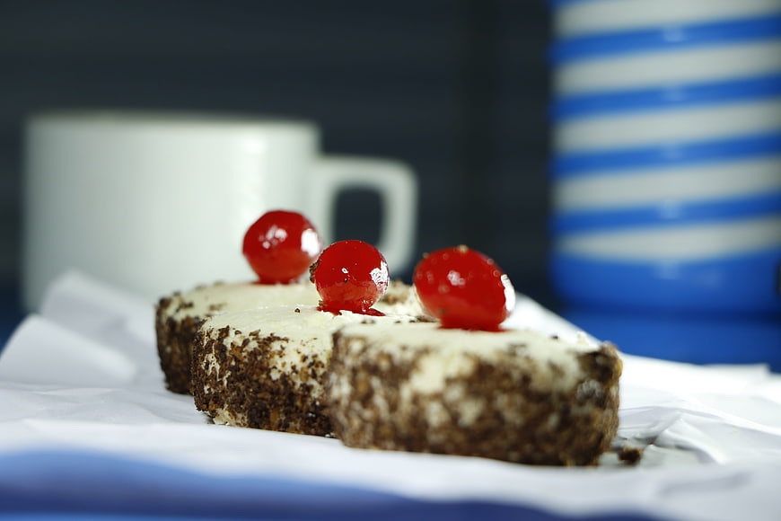 Chocolate cake slices with red cherries and coffee cup