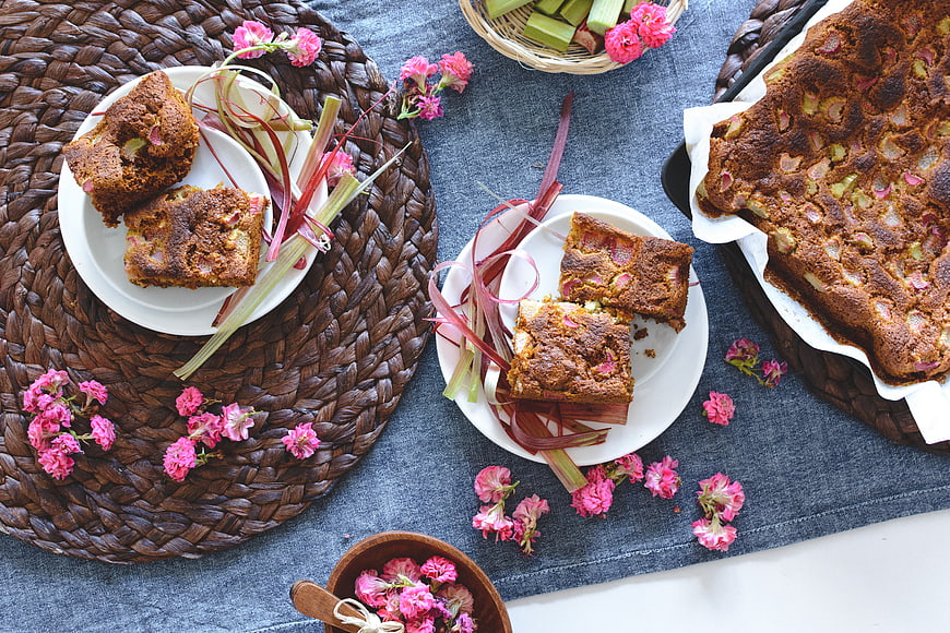 Homemade rhubarb cake with pink flowers on blue linen