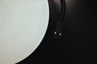 Close-up of white vinyl record on black turntable