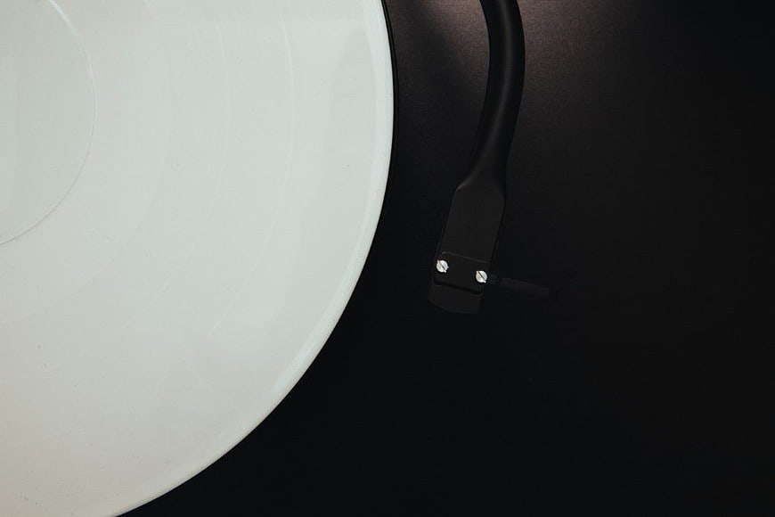 Close-up of white vinyl record on black turntable