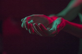 Close-up of hands with red and teal neon lighting