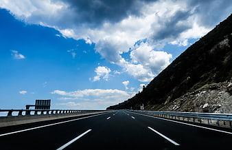 Empty Mountain Highway Under Dramatic Blue Sky