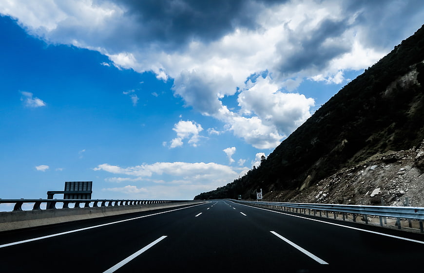 Empty Mountain Highway Under Dramatic Blue Sky