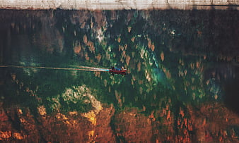 Aerial view of boat on river with autumn forest reflection