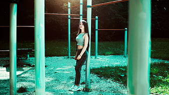 Young Woman Leaning on Outdoor Gym Pole