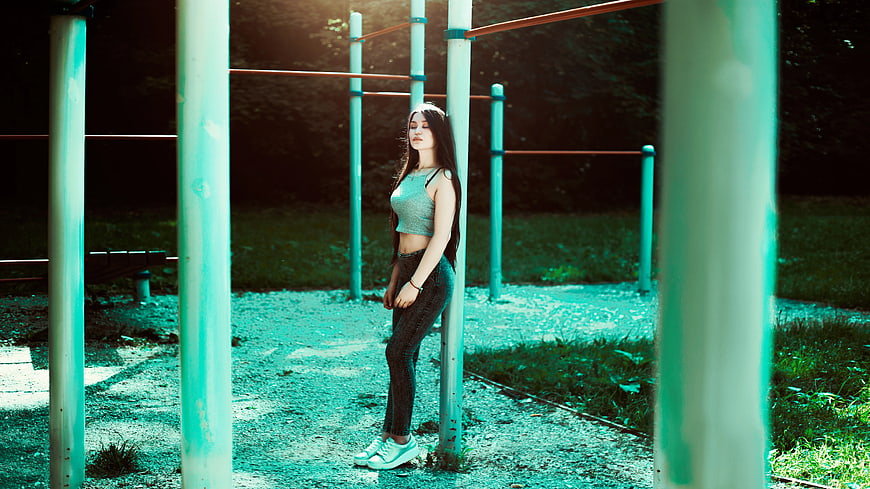 Young Woman Leaning on Outdoor Gym Pole
