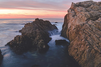 Dramatic Sunset Over Rocky Coastal Cliffs and Ocean