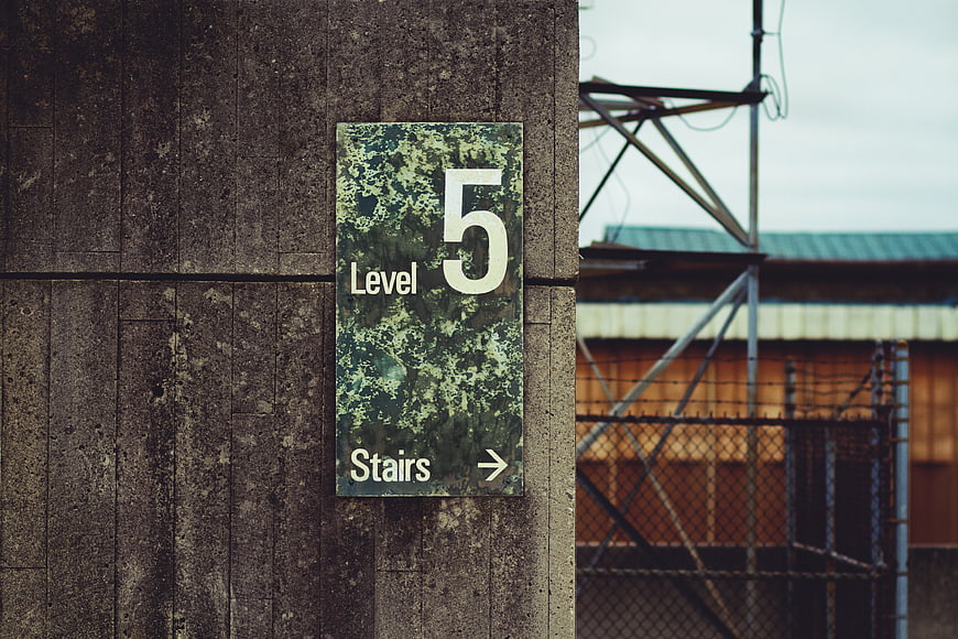 Weathered Level 5 Stairs Sign on Concrete Wall