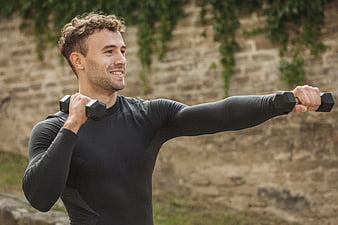 Smiling Man Exercising with Dumbbells Outdoors