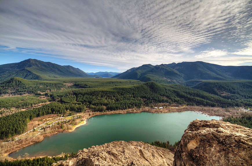 Panoramic View of Turquoise Lake Surrounded by Forested Mountains
