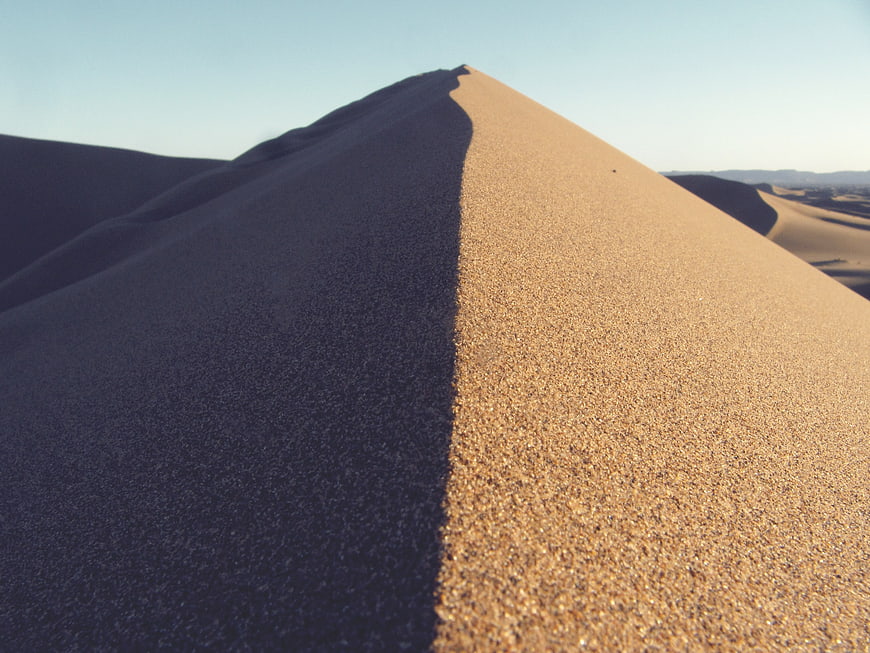 Close-up of sand dune ridge with sharp shadow contrast